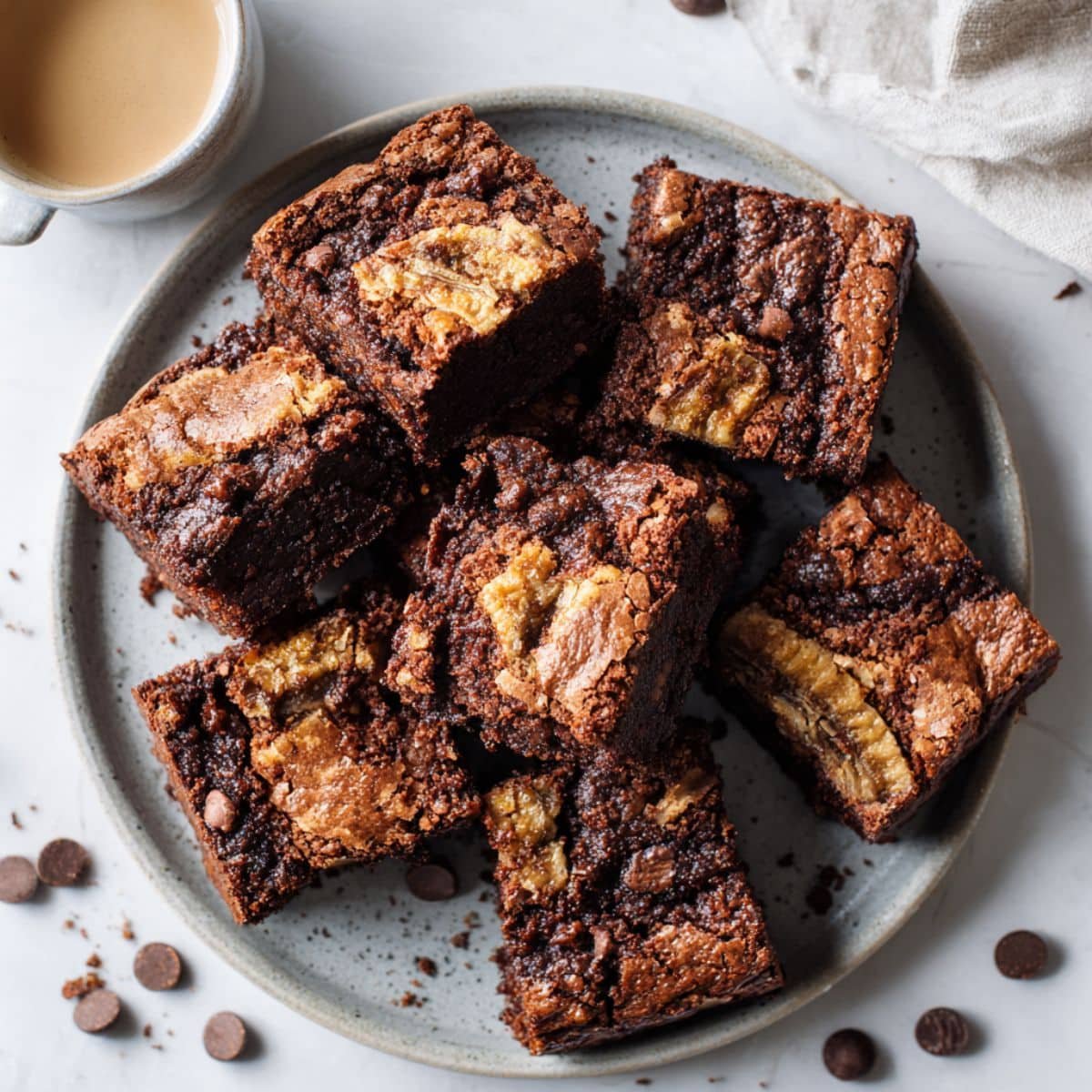 Fudgy banana bread brownies on a white counter.