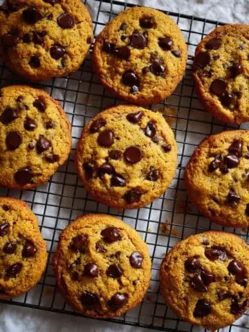 Freshly baked pumpkin chocolate chip cookies on a wire rack
