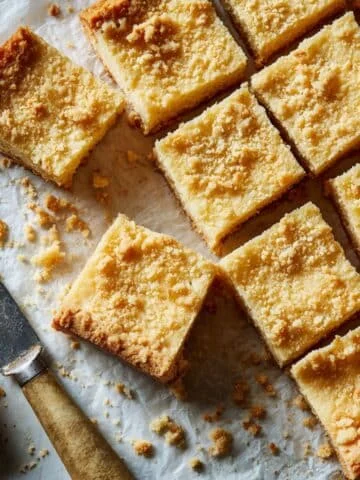 Freshly baked buttery shortbread bars on a white kitchen counter.