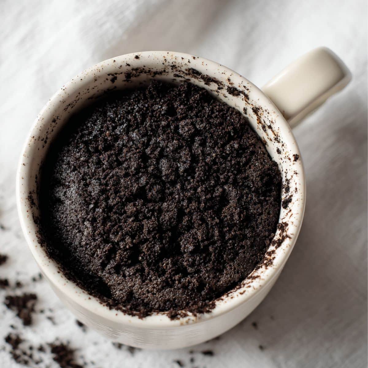 warm homemade Oreo mug cake on white kitchen table