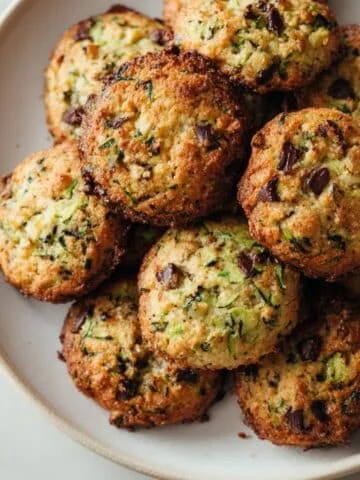 Homemade zucchini cookies with chocolate chips on a white kitchen table, photographed from above with a natural homemade feel.