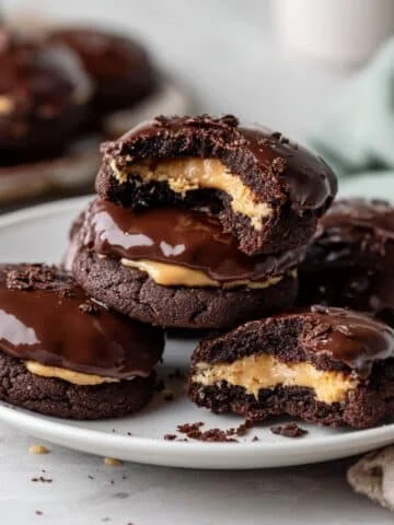 Homemade buckeye brownie cookies on a white kitchen table, showing their fudgy chocolate texture and creamy peanut butter center.