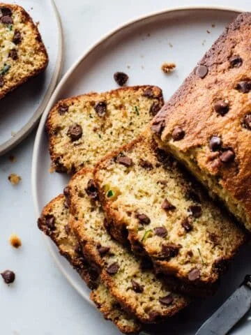 Homemade keto zucchini bread loaf on white table.